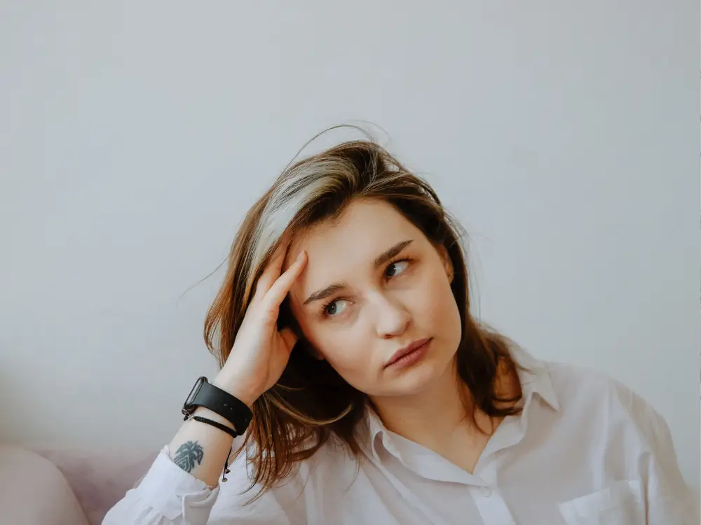 Mulher de 40+ com expressão pensativa ou curiosa, em ambiente tranquilo (casa ou natureza), com luz suave. O olhar pode estar voltado para o lado, como quem reflete.