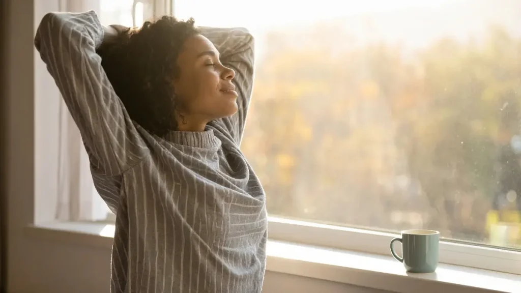 Mulher de 40 anos sentindo-se disposta e com energia pela manhã.
