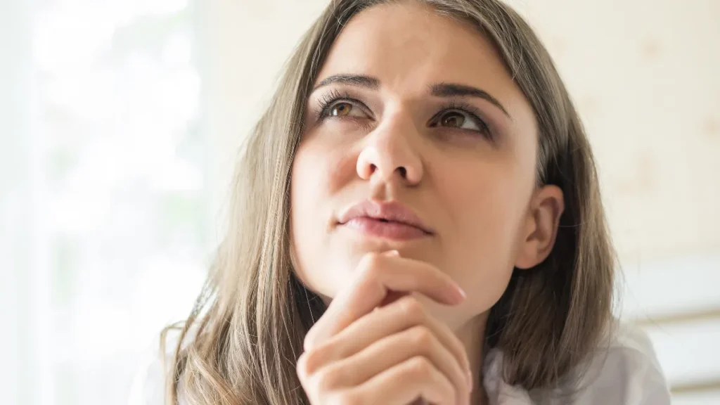Mulher pensativa refletindo sobre crenças limitantes após os 40